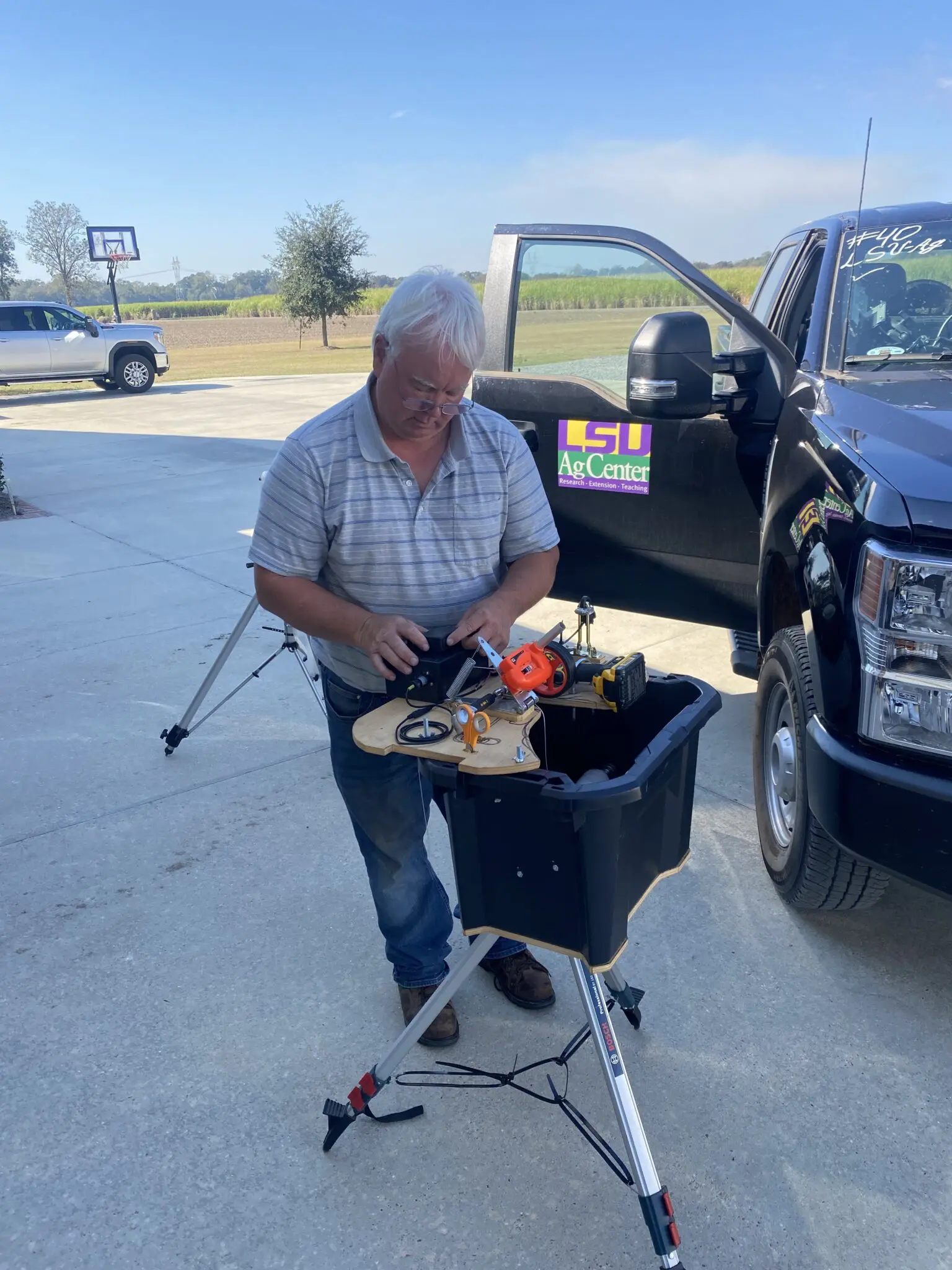 A man works on a piece of a machine on a portable table.